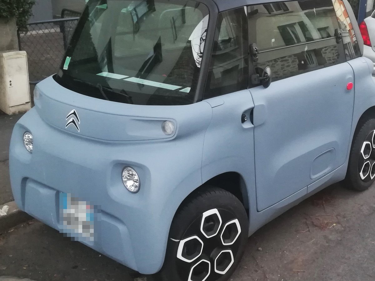 Jasnoniebieski Citroën Ami, elektryczny mikrosamochód 45 km/h, zaparkowany na ulicy